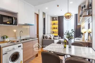 Modern open-layout kitchen and living room with stylish decor and natural light.