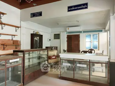 Spacious interior with display cabinets and wooden shelves, ideal for retail or office space.