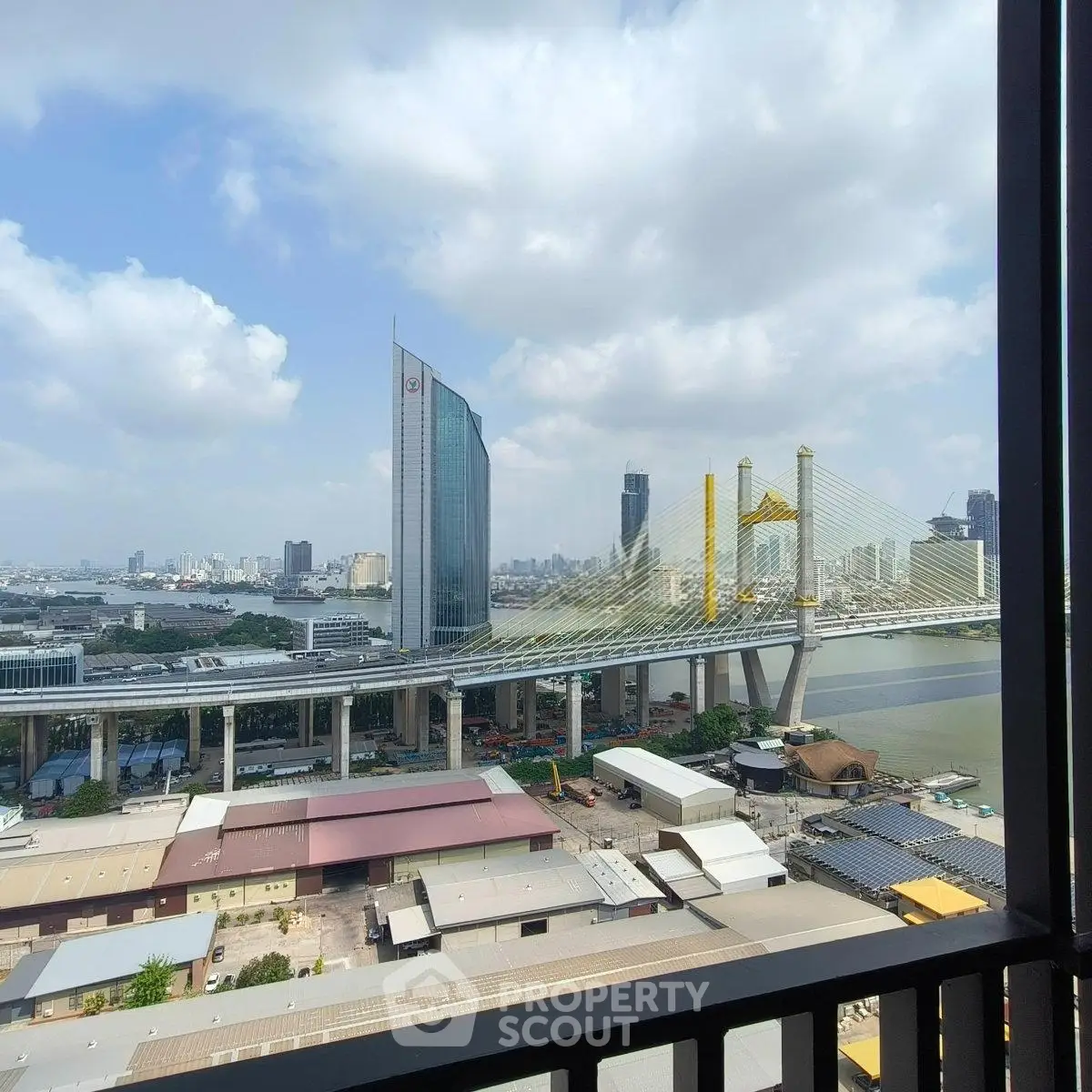 Stunning cityscape view from a high-rise balcony overlooking a modern bridge and skyline.