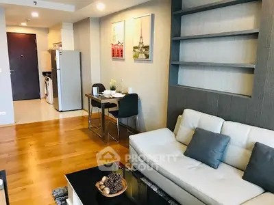 Modern living room with stylish decor, open layout, and kitchen appliances in a cozy apartment.