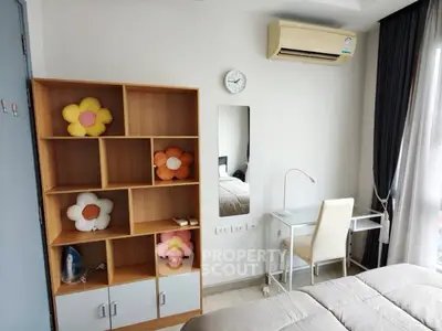 Cozy bedroom with modern decor, featuring a study desk, air conditioning, and a stylish bookshelf.