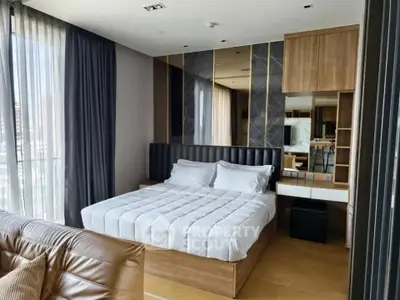Luxurious modern bedroom with elegant decor and large windows offering natural light.