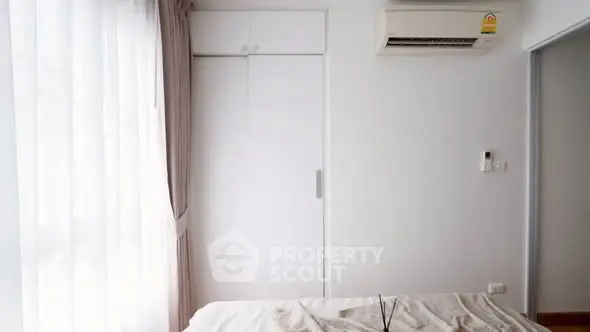 Bright bedroom with air conditioning and large window, perfect for natural light lovers.