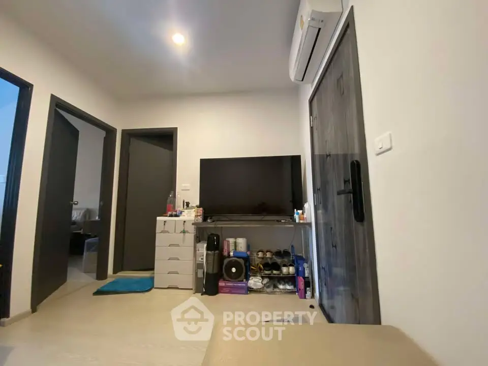 Modern living room with sleek TV setup and air conditioning, perfect for comfortable living.