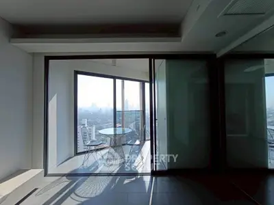 Modern apartment with glass doors leading to a balcony offering stunning city views.
