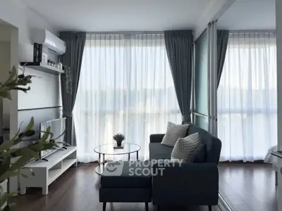 Modern living room with large windows, stylish sofa, and natural light.