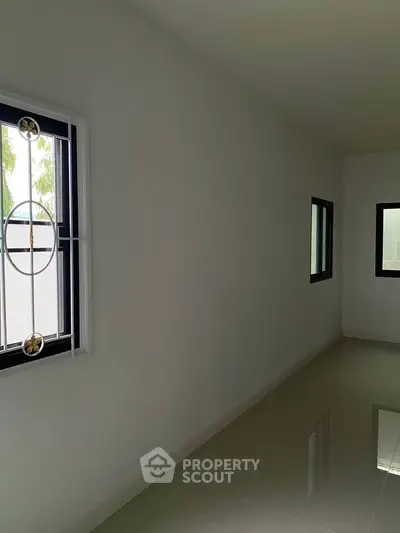 Minimalist interior space with sleek tiled flooring and modern window design.