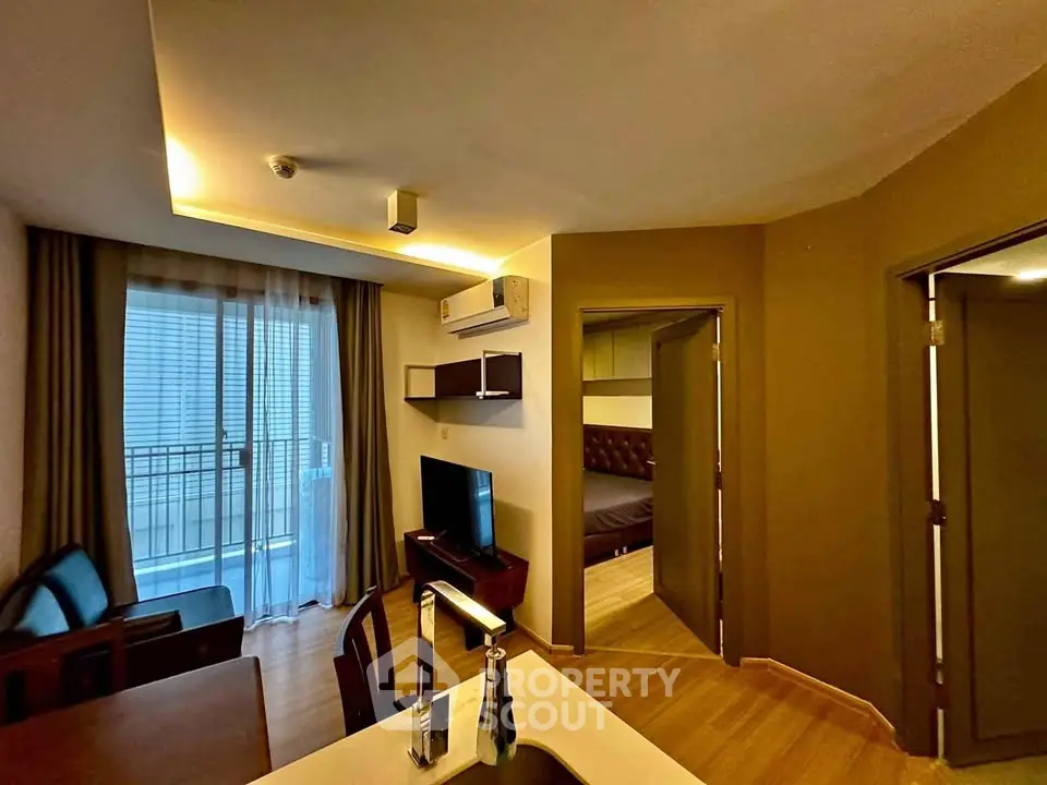 Modern apartment interior with open layout, featuring a cozy living area and a glimpse of the bedroom.