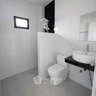 Modern minimalist bathroom with sleek fixtures and natural light.