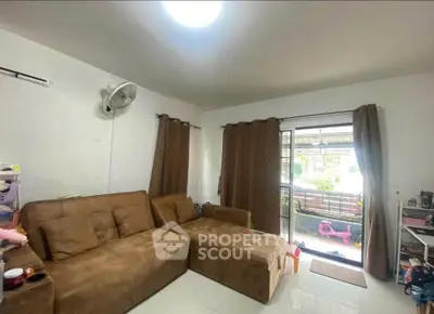 Cozy living room with brown sofa and garden view, perfect for relaxation.