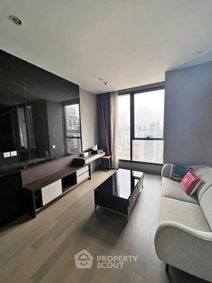 Modern living room with city view, sleek black accents, and stylish furniture in high-rise apartment.