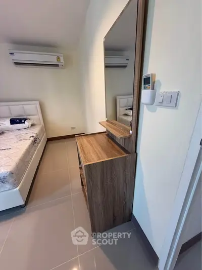 Modern bedroom with air conditioning and stylish wooden furniture