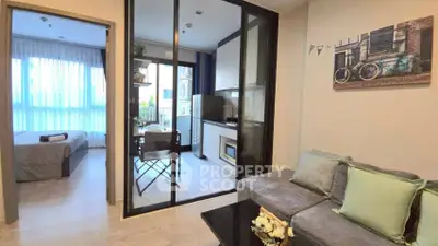 Modern apartment with glass partition, cozy living area, and stylish kitchen.