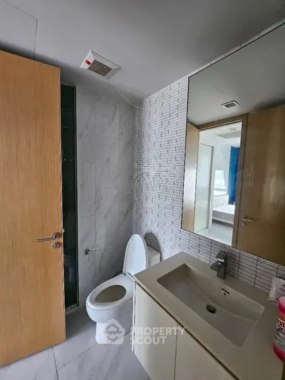 Modern bathroom with sleek fixtures and tiled walls in a contemporary home.