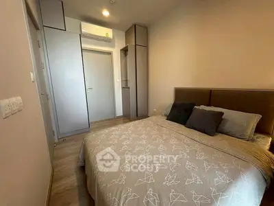 Cozy bedroom with modern decor and ample storage in a stylish apartment.
