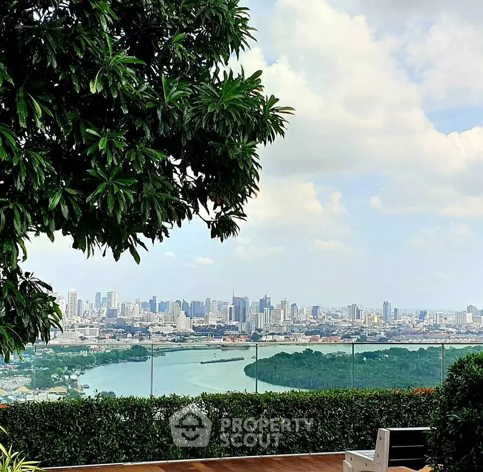 Stunning city skyline view from a lush rooftop garden with glass railing and seating area.
