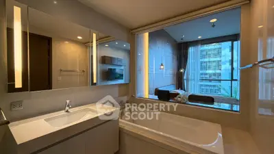 Luxurious bathroom with modern bathtub and view into elegant bedroom