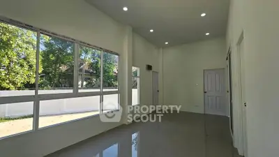 Spacious and bright living room with large windows and glossy tiled floor.