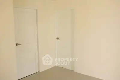 Minimalist interior with two white doors and beige walls