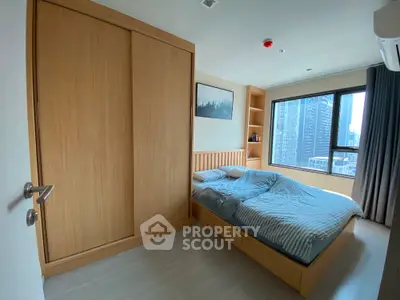 Modern bedroom with large window and built-in wardrobe in urban apartment