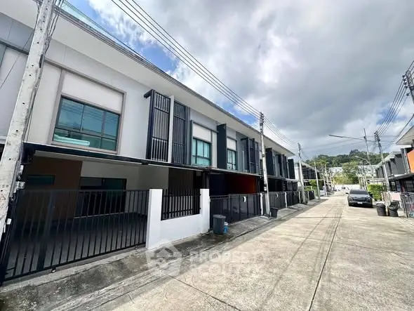 Modern townhouse exterior with clean lines and gated entrance in a serene neighborhood.