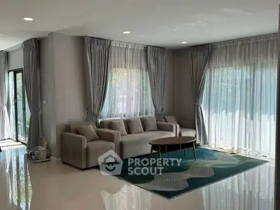 Spacious living room with modern decor and large windows for natural light