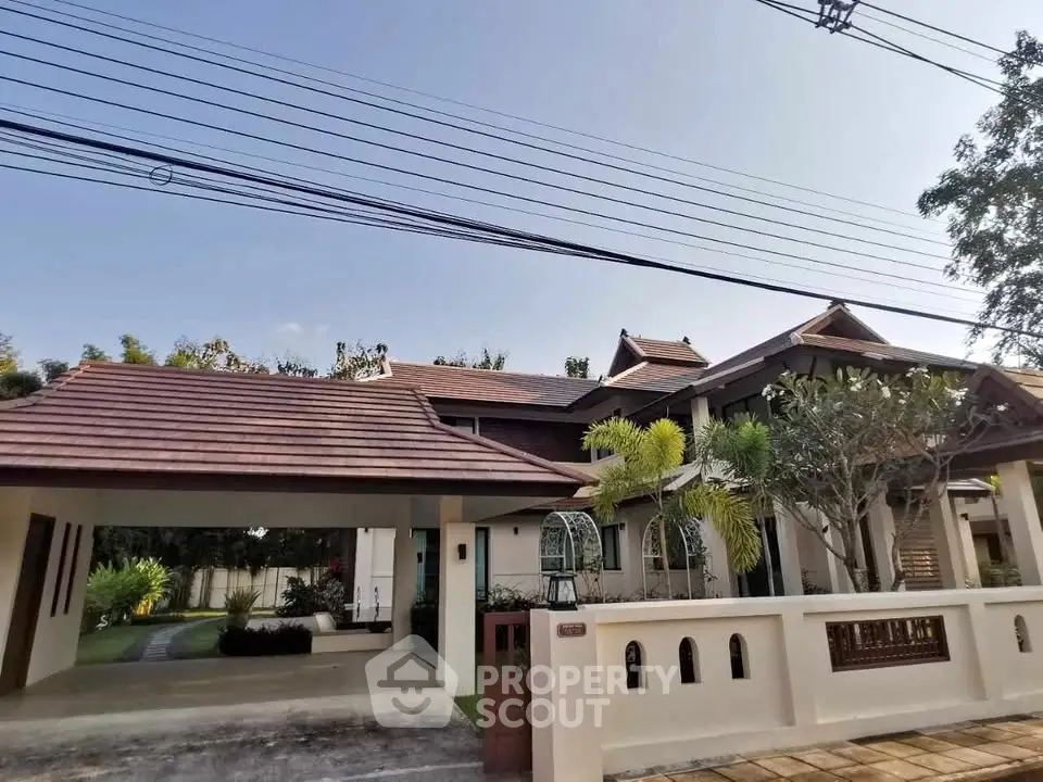 Charming traditional-style house with spacious driveway and lush greenery, perfect for serene living.