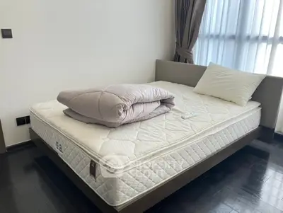 Spacious bedroom with modern bed and natural light through large window.