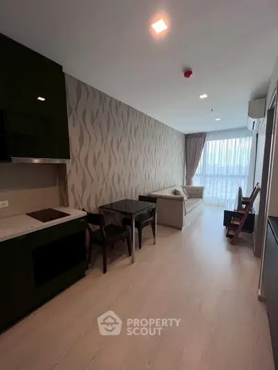 Modern living room with stylish wallpaper and natural light, featuring a cozy sofa and dining area.