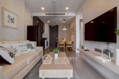 Modern living room with stylish decor and open layout, featuring a cozy sofa and large TV.