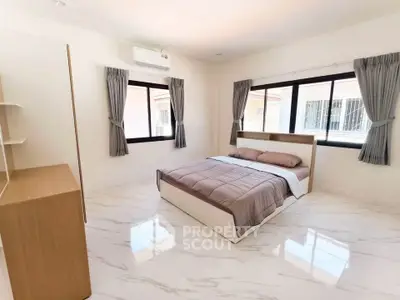 Spacious modern bedroom with large windows and elegant marble flooring.