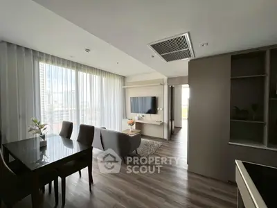 Modern living room with sleek furniture and large windows offering city views