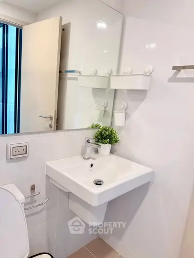 Modern bathroom with sleek white fixtures and a stylish sink, perfect for contemporary living.