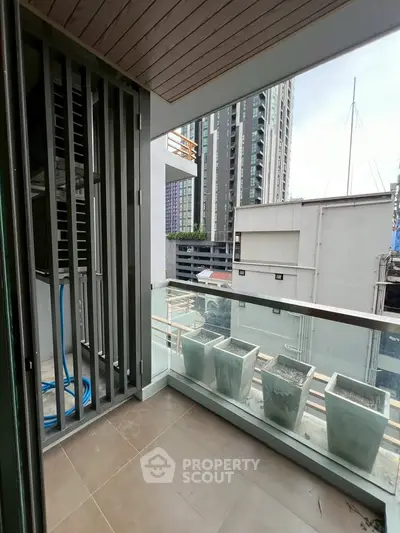 Modern balcony with glass railing and city view, perfect for urban living.