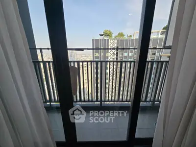 Modern balcony with city view and glass doors in high-rise apartment