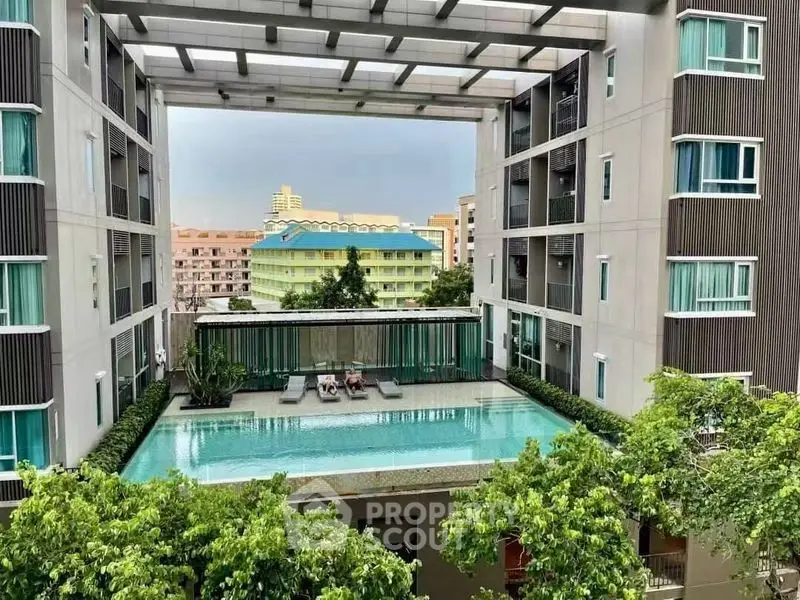 Modern apartment building with rooftop pool and lush greenery