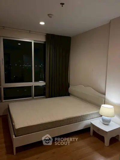 Cozy bedroom with city view, featuring a comfortable bed and ambient lighting.