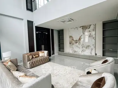 Luxurious modern living room with elegant sofas and marble accent wall.