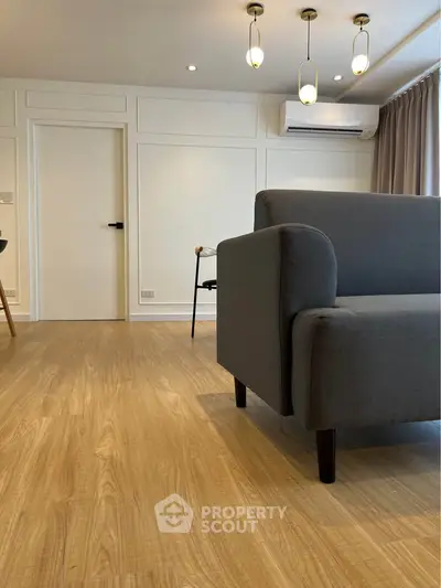 Modern living room with stylish grey sofa and elegant lighting