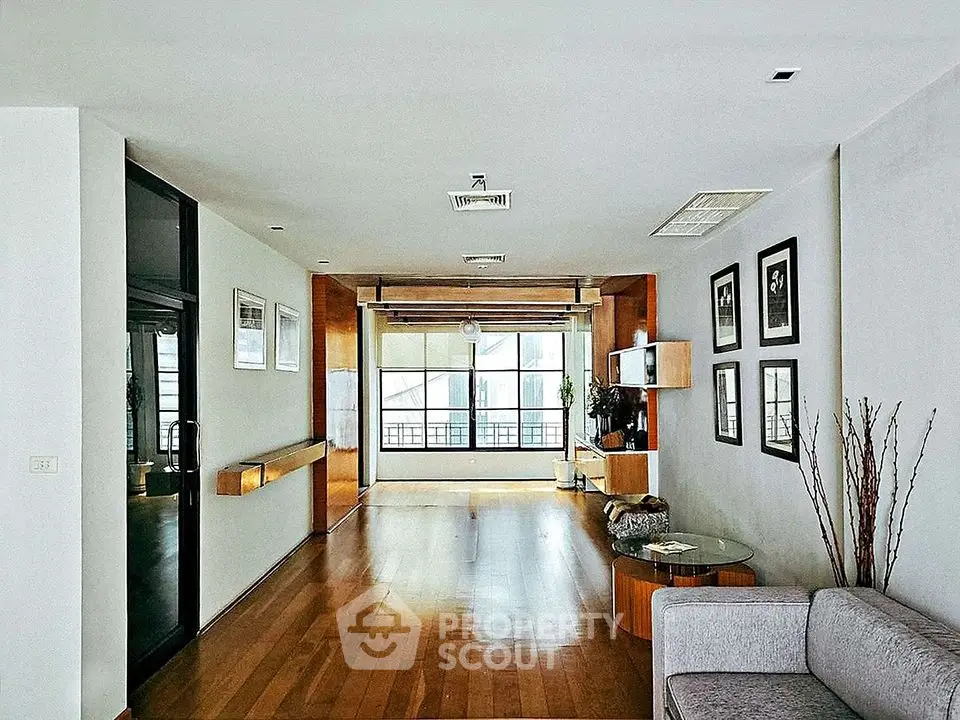 Spacious modern living room with wooden flooring and large windows