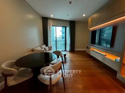Modern living room with large TV and dining area, featuring a balcony with city view.