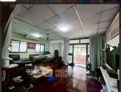 Spacious living room with wooden flooring and large windows for natural light.