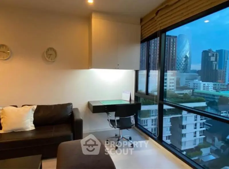 Modern living room with city view, featuring sleek furniture and large windows.