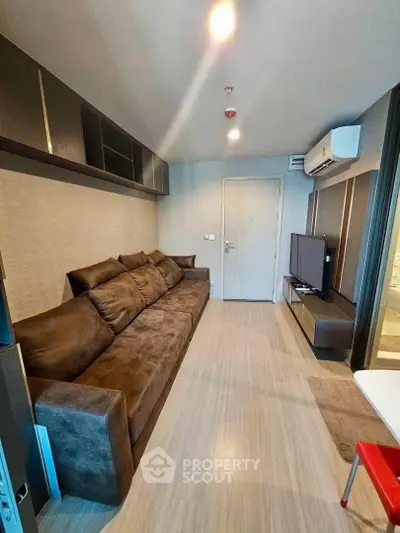 Modern living room with sleek design, featuring a comfortable brown sofa and wall-mounted TV.