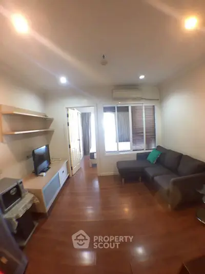 Cozy living room with modern furniture and wooden flooring in a stylish apartment.