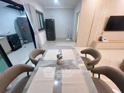 Modern dining area with marble table and open view to laundry space