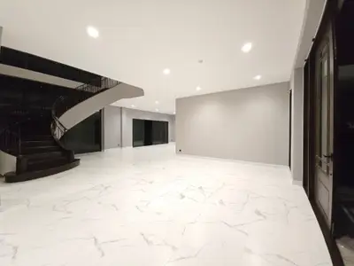 Spacious modern living room with elegant staircase and marble flooring