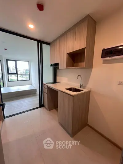 Modern kitchen with sleek wooden cabinetry and open layout in a bright apartment.