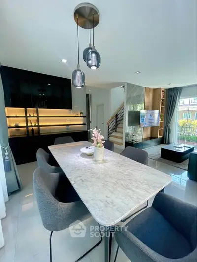 Modern dining area with elegant marble table and stylish lighting in a contemporary home interior.