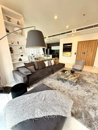 Luxurious modern living room with plush gray sofa, elegant decor, and open layout for sophisticated living.